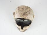 a white mask with a black face on a white surface