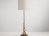 une lampe posée sur une table, avec un abat-jour blanc