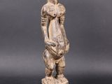 a wooden statue of a woman holding a basket in her hands