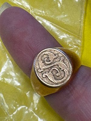 une personne tenant une bague sur laquelle est posée une pièce de monnaie