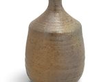 a brown vase that is sitting on a white surface