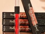 a close up of a bottle of lipstick next to a stack of boxes