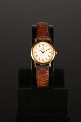 a gold wrist watch with a brown leather band and roman numerals