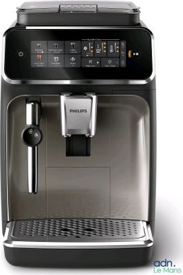 La machine à café est posée sur une surface blanche, à côté d'une tasse de café.