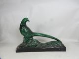 statue of a pheasant resting on a rock on a white background