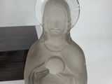 a statue of a woman holding a heart next to two plates