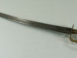 a close up of a sword on a table with a white background