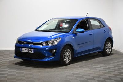une voiture bleue garée dans une pièce au sol en damier
