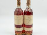 deux bouteilles de vin posées l'une à côté de l'autre sur une surface blanche