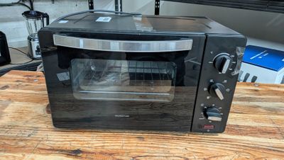 un four grille-pain noir posé sur une table en bois