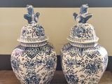 pair of blue and white vases with birds on them on a wooden table