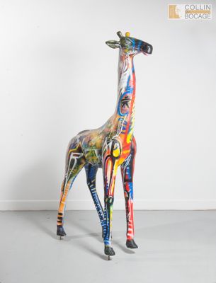 une girafe debout dans une pièce aux murs blancs