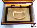 a ring in a wooden box with a gold background