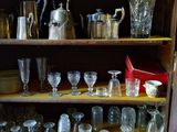 de nombreux verres et pichets posés sur une étagère dans un placard