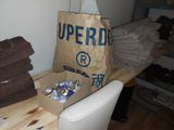 a brown paper bag sitting on top of a table next to a pile of towels
