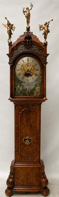 une horloge de parquet en bois surmontée d'anges