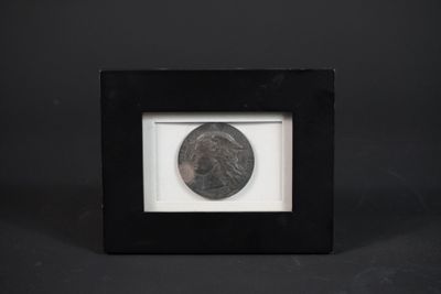 une photo en noir et blanc d'une pièce de monnaie dans un cadre noir