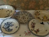 many plates and bowls sitting on a white table cloth