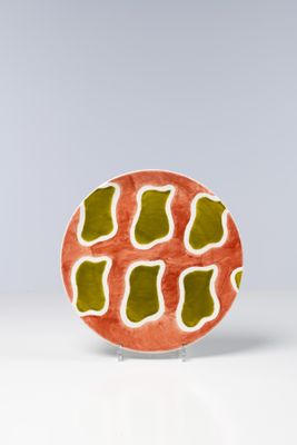 une assiette orange et verte posée sur une table blanche