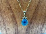 un gros plan d'un collier orné d'une pierre bleue
