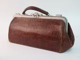 brown leather purse with silver clasp and handle on white background