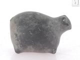 a small animal figurine sitting on a white surface