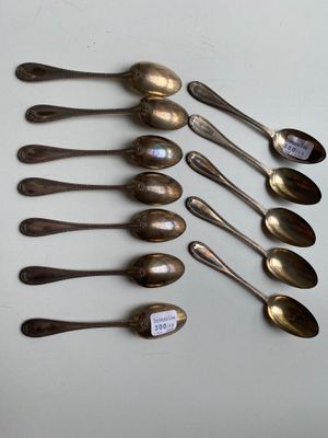 six silver spoons are lined up in a row on a table