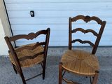 two wooden chairs sitting next to each other in front of a garage door