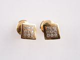 pair of gold and diamond earrings on a white surface