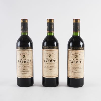 trois bouteilles de vin rouge posées l'une à côté de l'autre sur une surface blanche