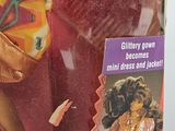 barbie doll in a box with a gold dress and accessories