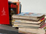 a stack of books sitting on a table next to a red book