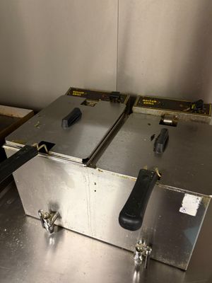 deux friteuses posées sur un plan de travail en métal