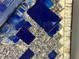 a picture of a blue and white mosaic tile on a wall
