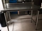 a stainless steel table in the middle of a kitchen