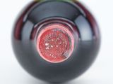 close up of a bottle of wine with a red cap