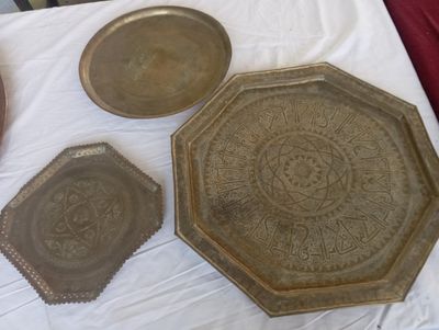 trois plateaux en métal posés sur une table recouverte d'une nappe blanche