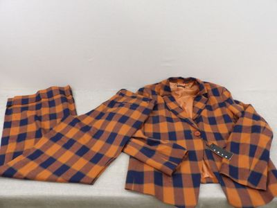 an orange and blue plaid suit sitting on top of a white table