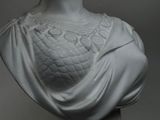 a statue of a woman wearing a shawl on a pedestal