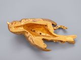 a gold frog brooch on a gray surface