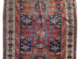 a red, blue and green rug with a design on it