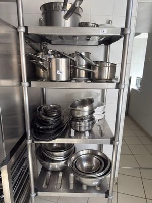 many pots and pans on the shelves in the kitchen
