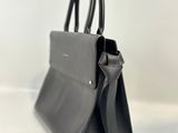 a black handbag sitting on a white surface