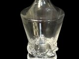 a glass bottle with a glass stopper on a black surface