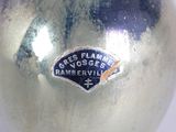 a silver vase that has a sticker on it