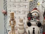 a snowman sitting on a table next to a calendar