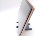 a tablet computer sitting on a stand on a white surface