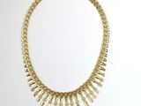 gold plated necklace with spikes on a white background