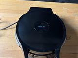 an image of a black and white toaster on a wooden table