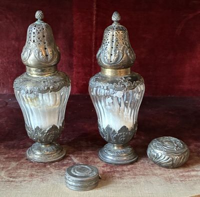 two silver vases sitting on top of a table